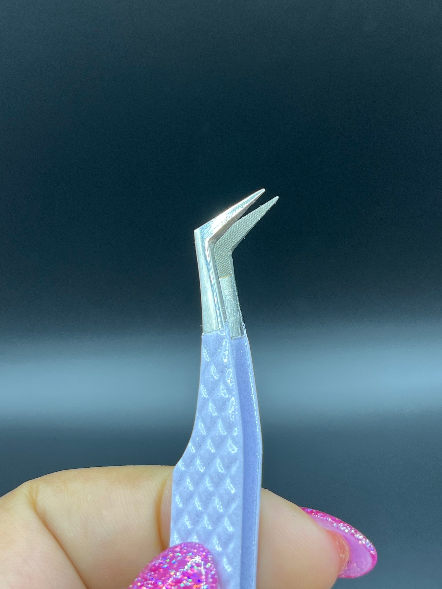 Close-up view of precision fiber tip tweezers with ergonomic handles, ideal for lash extensions and beauty professionals.