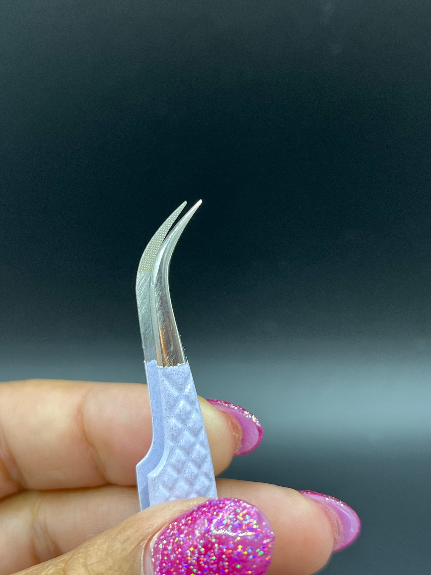 Close-up view of precision fiber tip tweezers with ergonomic handles, ideal for lash extensions and beauty professionals.
