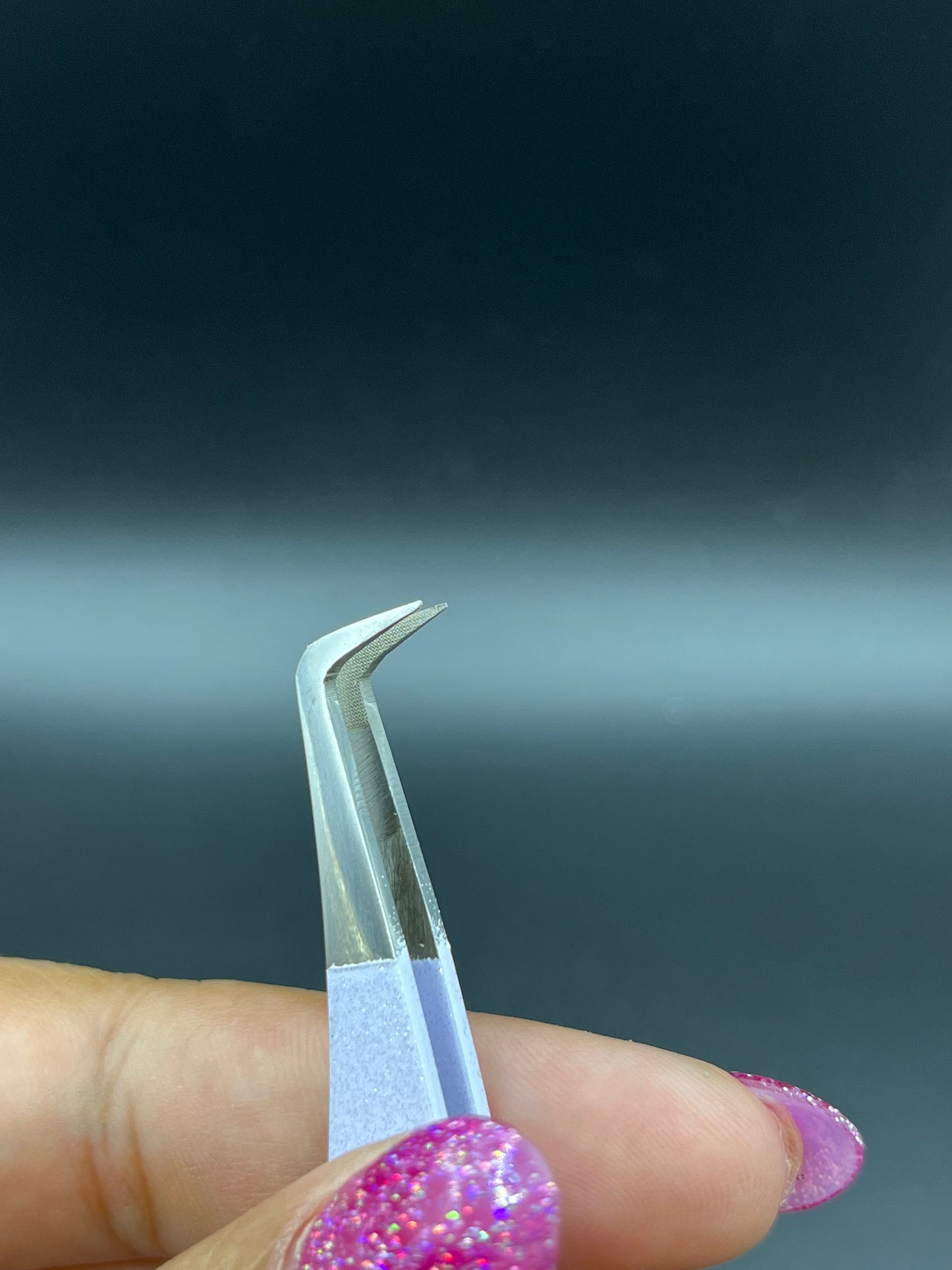 Close-up view of precision fiber tip tweezers with ergonomic handles, ideal for lash extensions and beauty professionals.